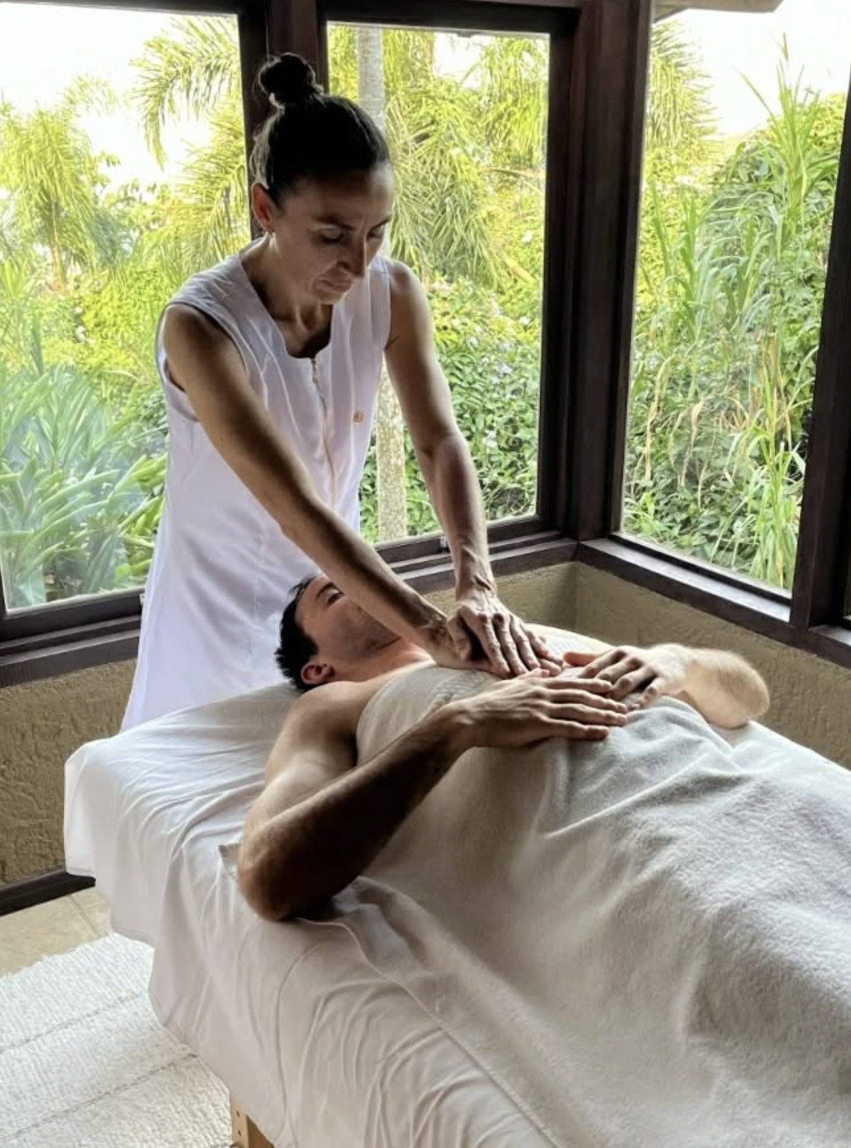 Paula Olmos realizando massagem em seu espaço com vista para a natureza